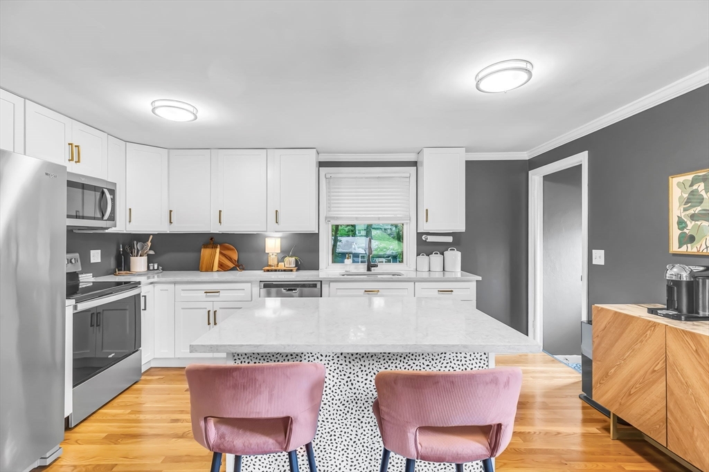 71 Endecott Street Springfield, MA 01118 - Photo 15 of 42 a kitchen with granite countertop a stove a refrigerator and white cabinets