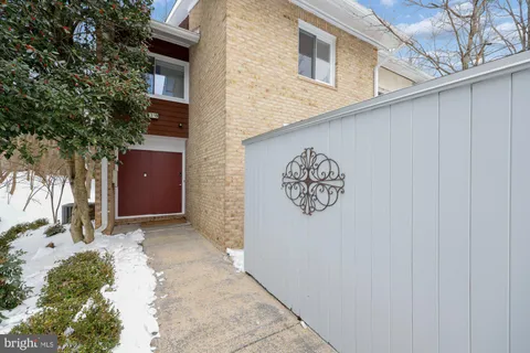 a view of a house with a snow on the wall and a tree