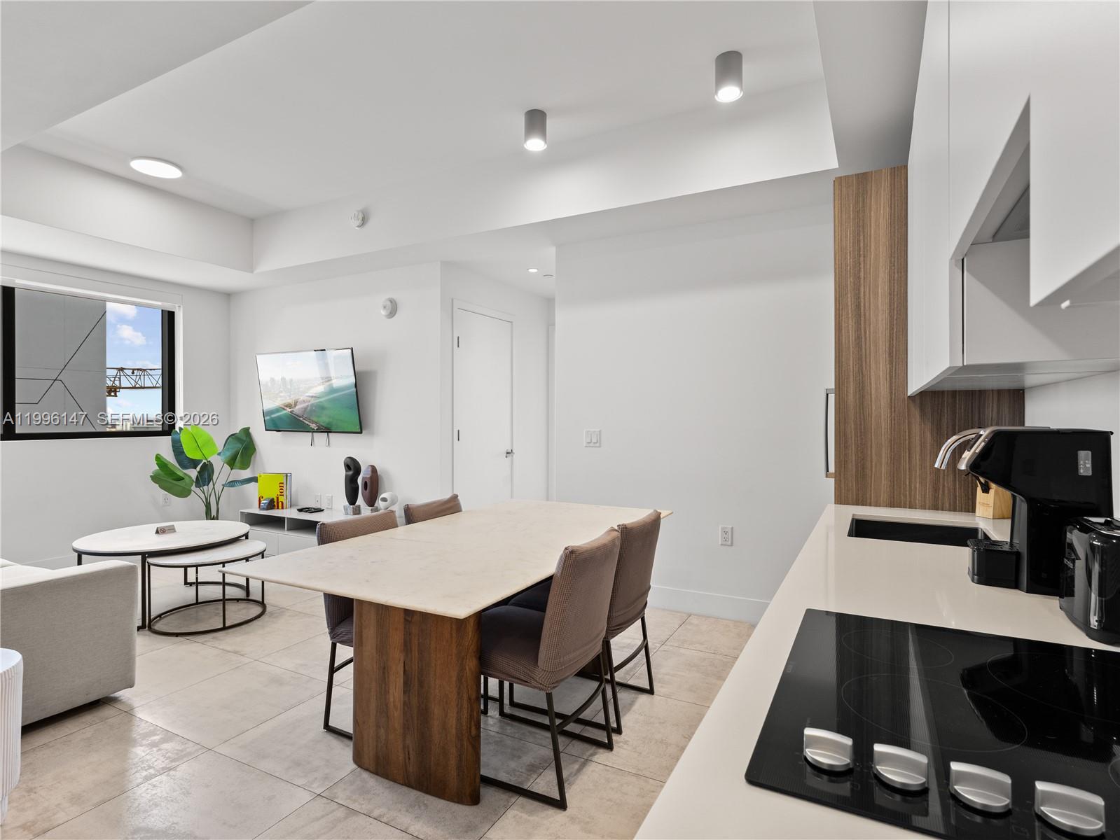 239 Southwest 9th Street, Unit 1403 Miami, FL 33130 - Photo 15 of 33 a room with a table chairs and a kitchen view