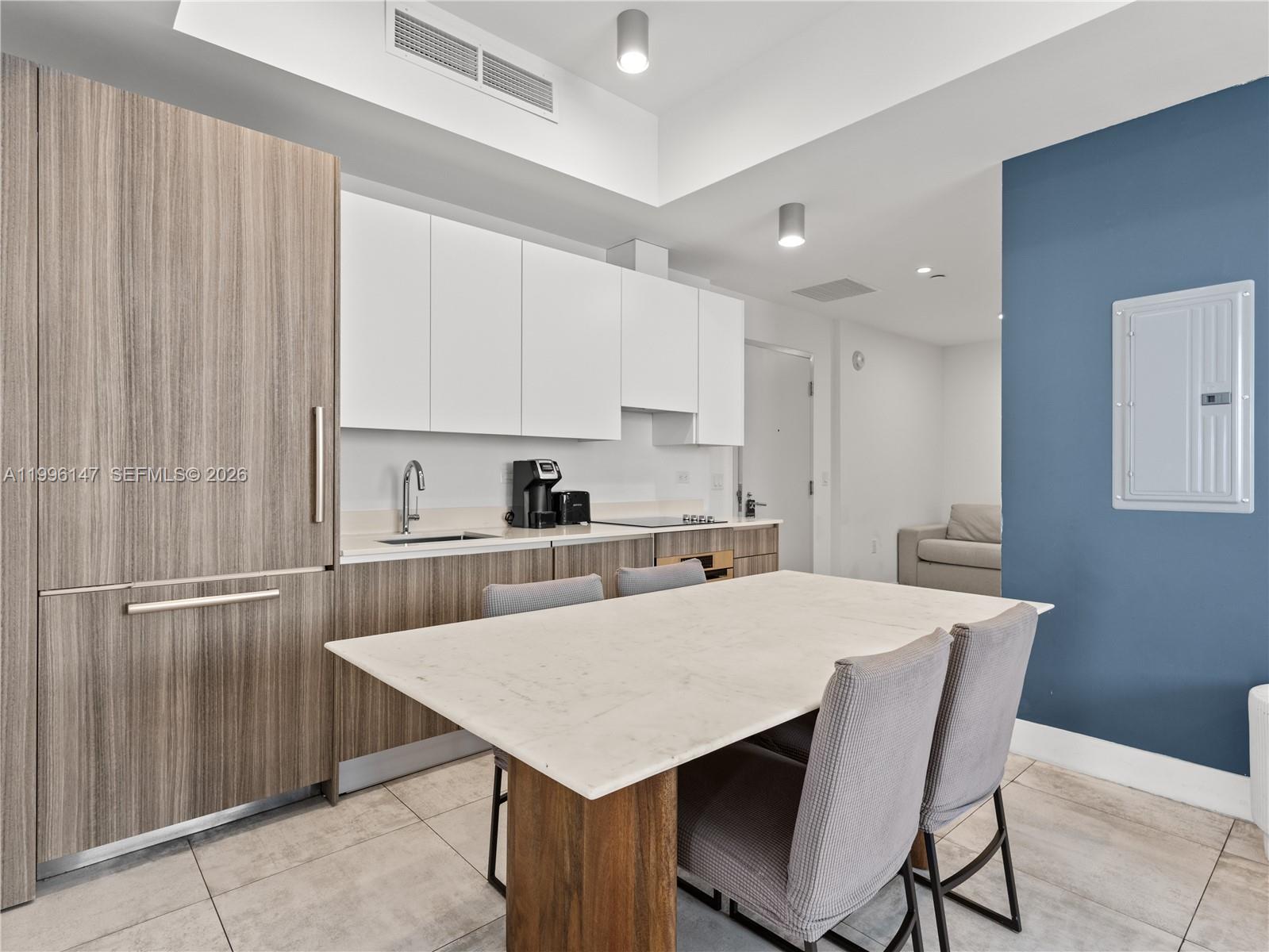 239 Southwest 9th Street, Unit 1403 Miami, FL 33130 - Photo 17 of 33 a kitchen with stainless steel appliances a table chairs and a refrigerator