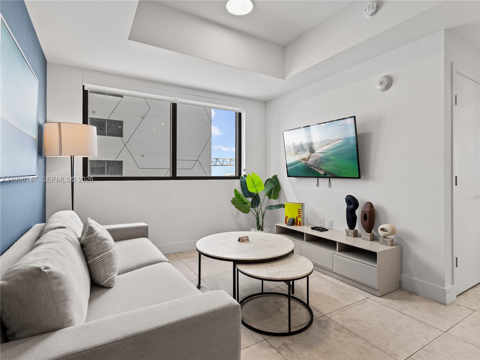 239 Southwest 9th Street, Unit 1403 Miami, FL 33130 - Photo 21 of 33 a living room with furniture and a flat screen tv