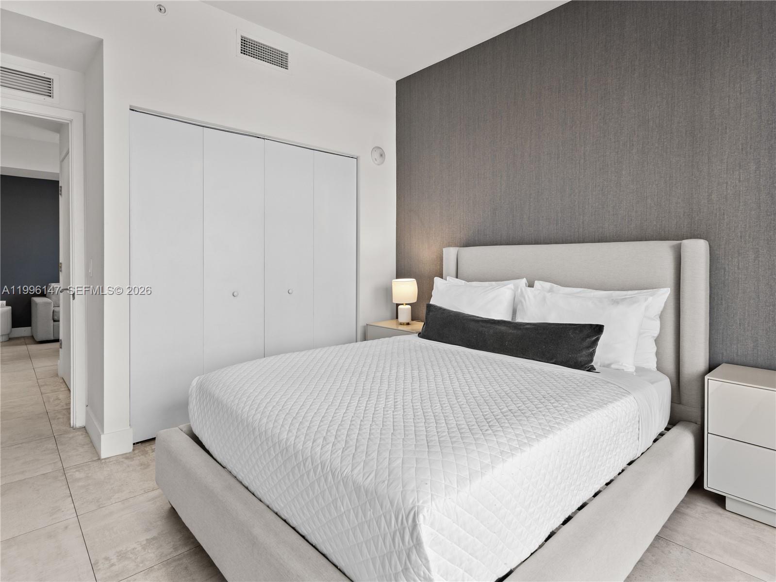 239 Southwest 9th Street, Unit 1403 Miami, FL 33130 - Photo 8 of 33 a bedroom with a bed and a refrigerator