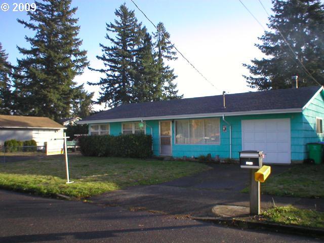 a front view of a house with a yard and tree