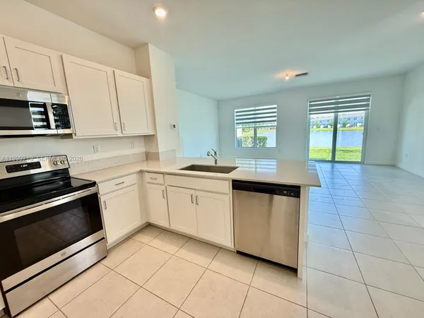 a kitchen with stainless steel appliances granite countertop a sink and a stove