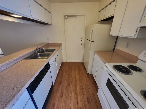a kitchen with a wooden floor a stove and a refrigerator