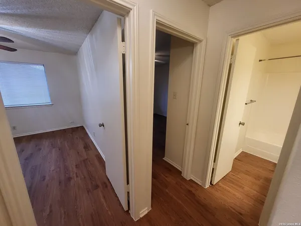 a view of a hallway with wooden floor and staircase