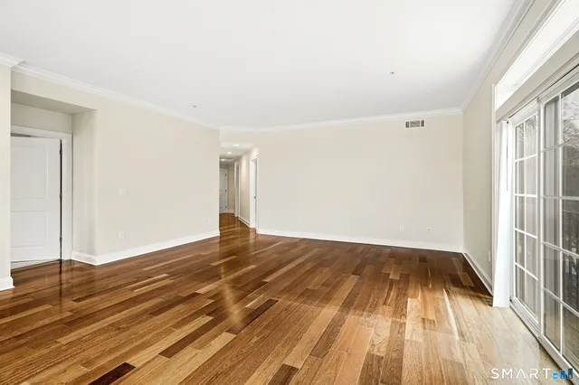a view of a room with wooden floor and white walls
