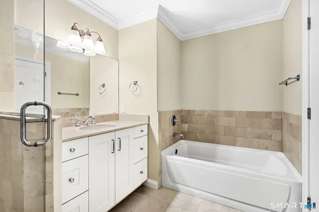 a bathroom with a tub a sink and mirrors