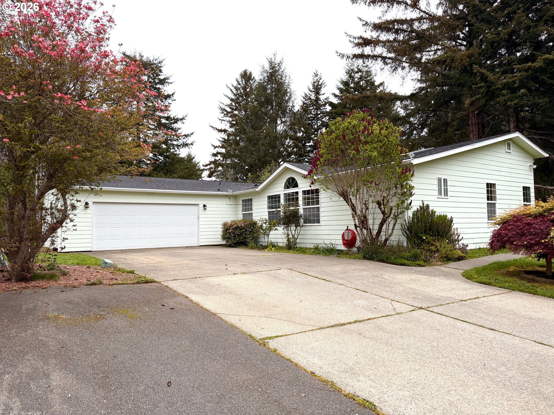 1157 8th Street Bandon, OR 97411 - Photo 1 of 46 a front view of a house with a yard and garage