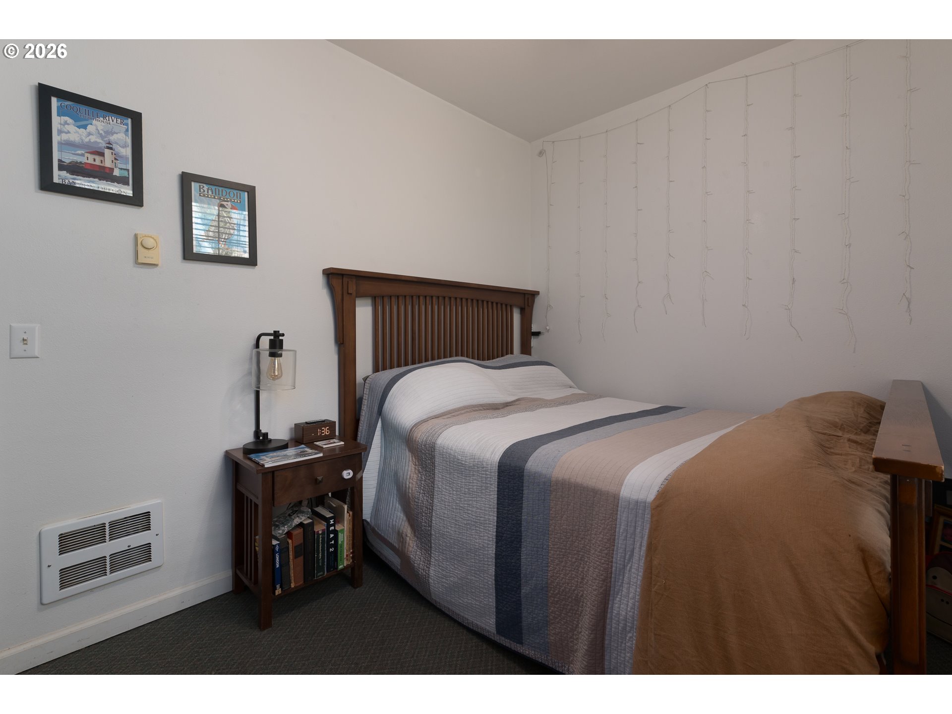 1157 8th Street Bandon, OR 97411 - Photo 29 of 46 a bed sitting in a bedroom next to a window