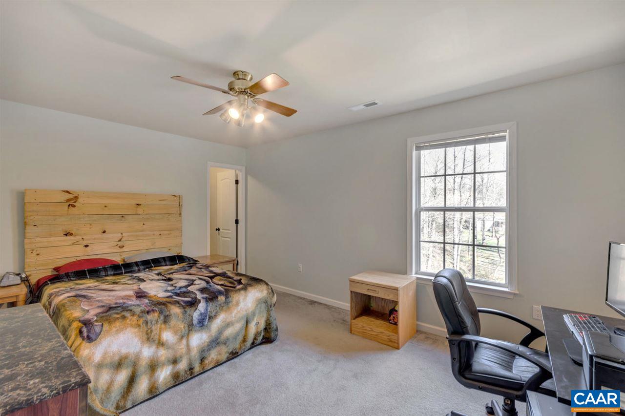 127 Larkspur Road Ruckersville, VA 22968 - Photo 14 of 29 a bedroom with a bed a table and chair