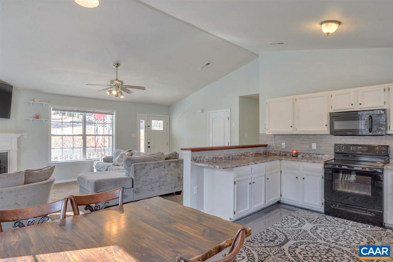127 Larkspur Road Ruckersville, VA 22968 - Photo 9 of 29 a kitchen with a stove a sink a dining table and chairs
