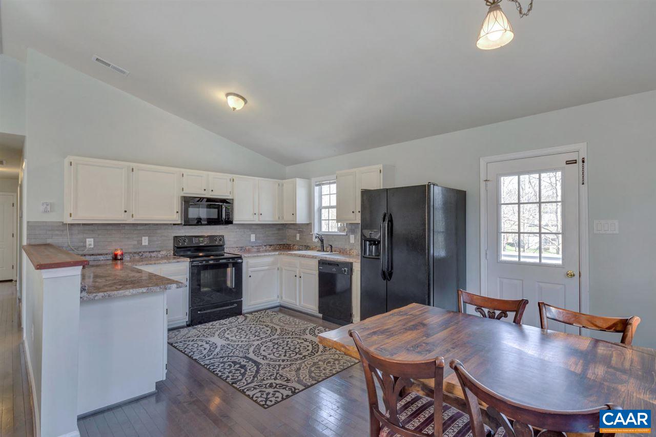 127 Larkspur Road Ruckersville, VA 22968 - Photo 10 of 29 a kitchen with stainless steel appliances granite countertop a stove a refrigerator a sink a dining table and chairs
