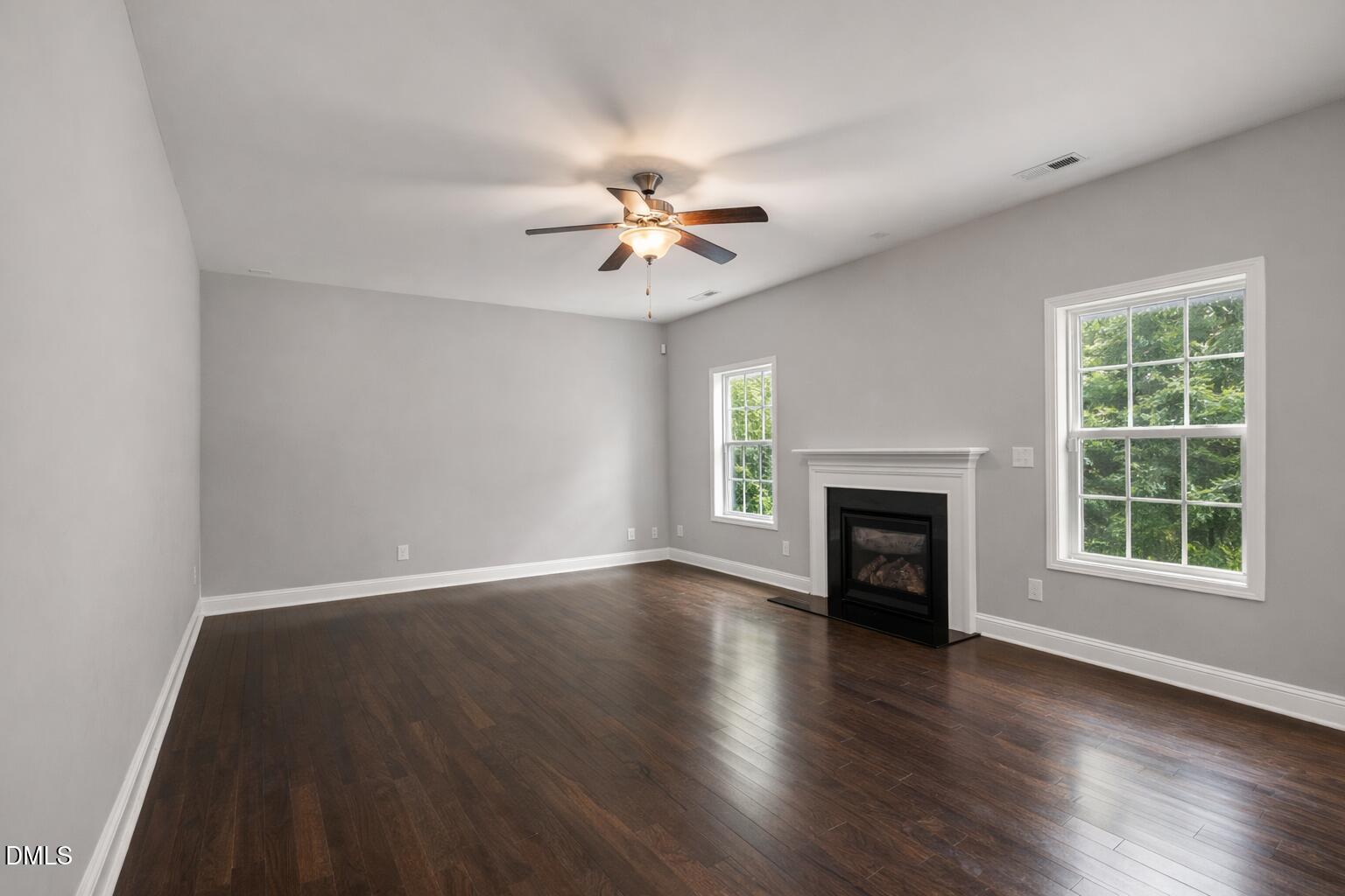 3401 Grosbeak Way Raleigh, NC 27616 - Photo 4 of 13 an empty room with windows fireplace and a hardwood floor