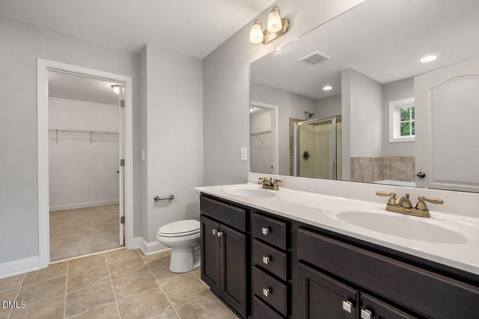 3401 Grosbeak Way Raleigh, NC 27616 - Photo 8 of 13 a spacious bathroom with a granite countertop sink a toilet a mirror and shower