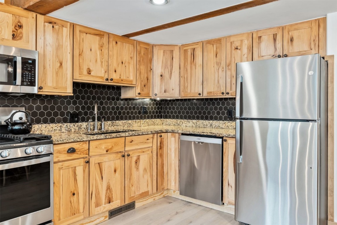 209 Miners Creek Road Frisco, CO 80443 - Photo 11 of 32 a kitchen with stainless steel appliances granite countertop a refrigerator sink and cabinets