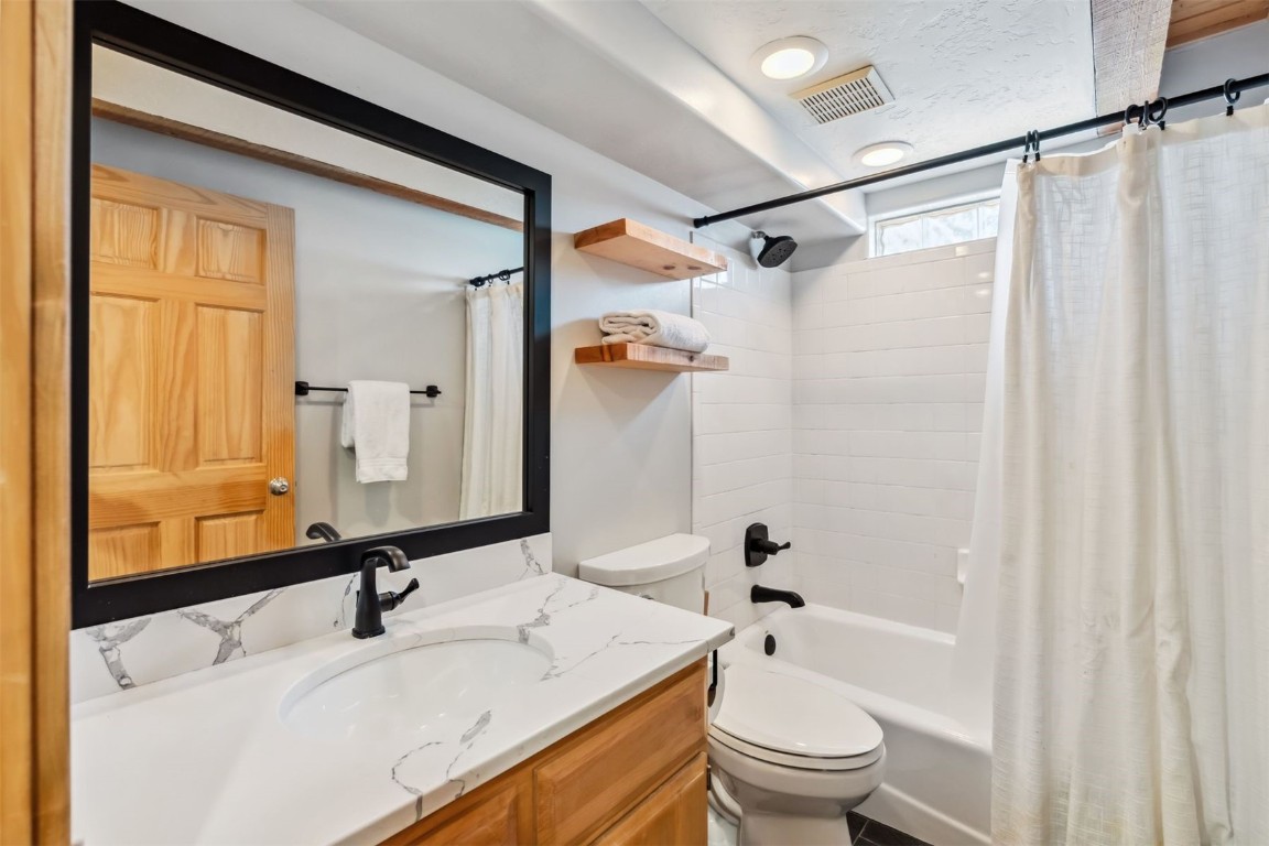209 Miners Creek Road Frisco, CO 80443 - Photo 15 of 32 a bathroom with a granite countertop sink toilet and shower