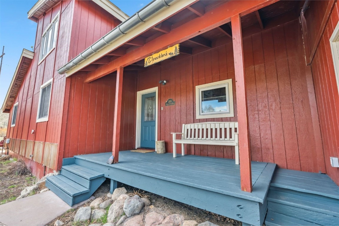 209 Miners Creek Road Frisco, CO 80443 - Photo 2 of 32 a wooden bench sitting in front of a door
