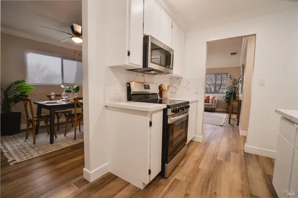 a kitchen with stainless steel appliances a stove a sink cabinets and a wooden floor
