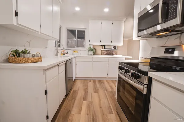 a kitchen with a sink a stove and cabinets