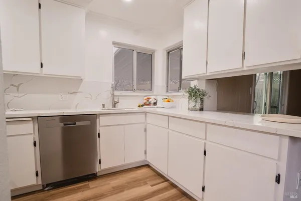 a kitchen with white cabinets and white appliances