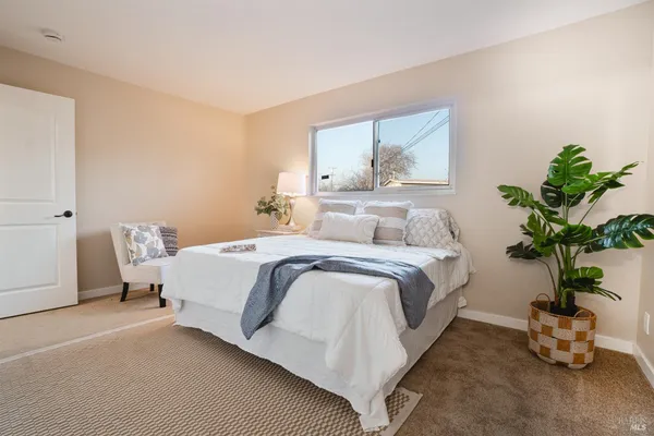 a bedroom with a bed and a potted plant