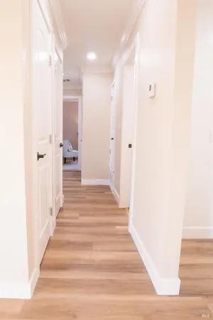 a view of a hallway with wooden floor and staircase