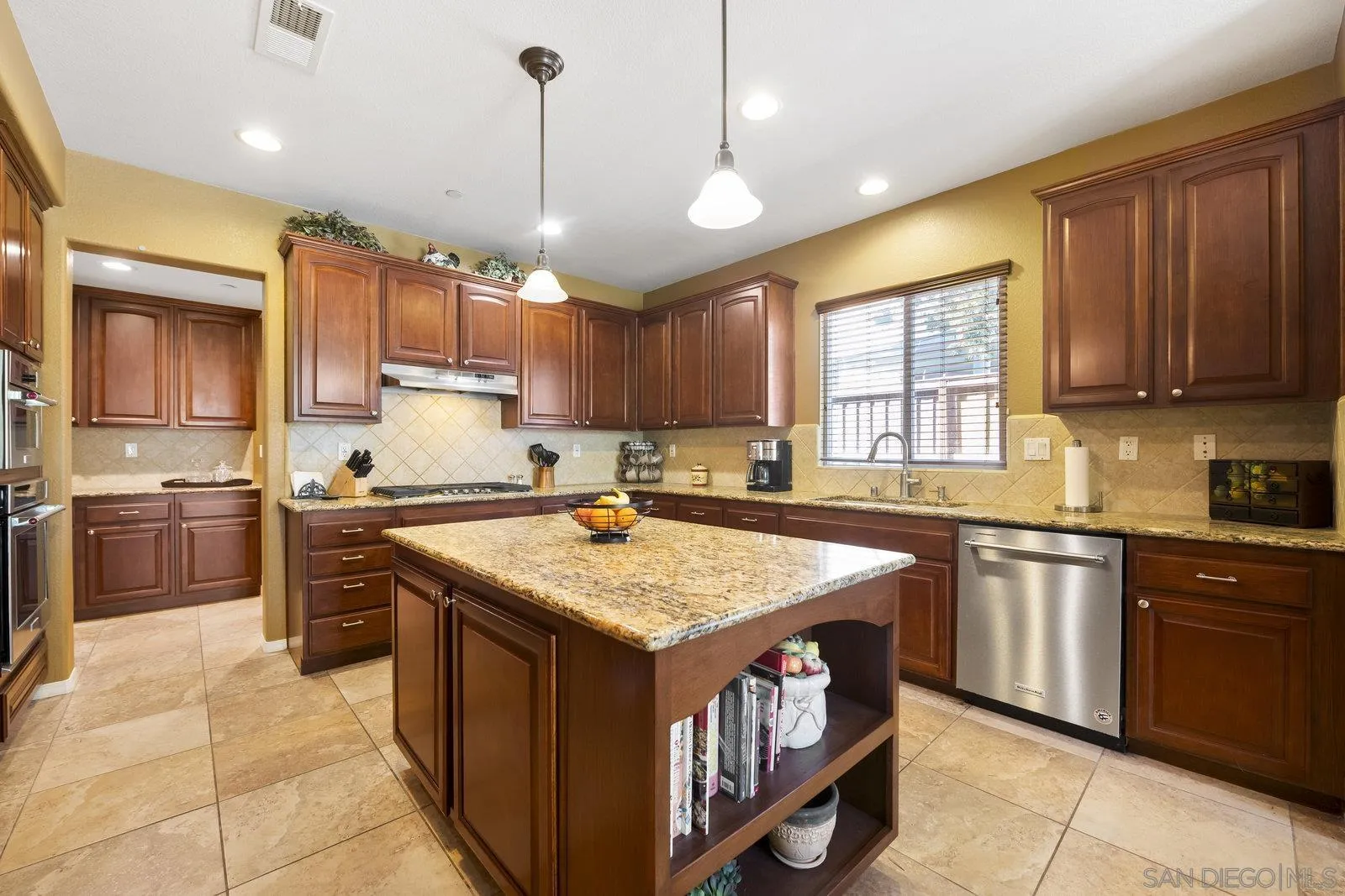 5545 Nanday Court Oceanside, CA 92057 - Photo 13 of 38 a kitchen with a stove sink cabinets and window