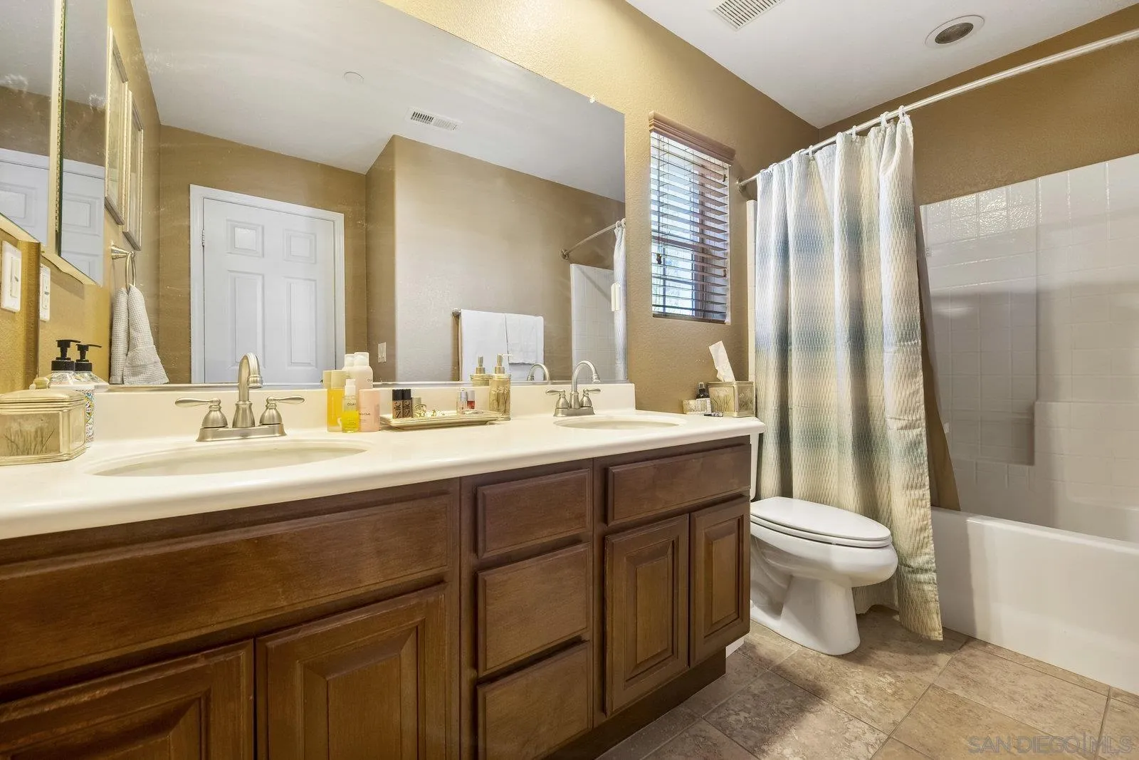 5545 Nanday Court Oceanside, CA 92057 - Photo 32 of 38 a bathroom with a double vanity sink toilet and a mirror