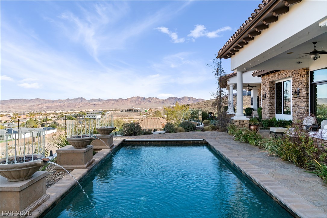 1123 Christian Road Henderson, NV 89002 - Photo 60 of 94 An inviting pool area with serene water features and a sweeping view of distant mountains.