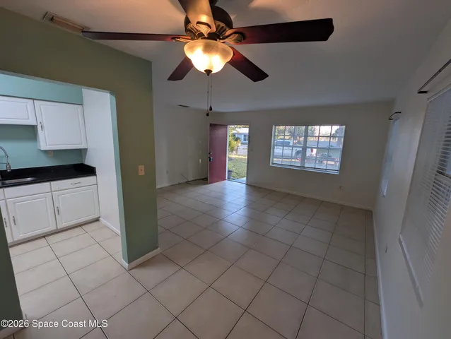 a view of an empty room and window chandelier fan