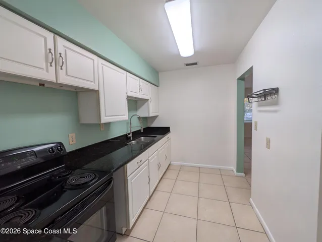 a kitchen with granite countertop a stove and a sink
