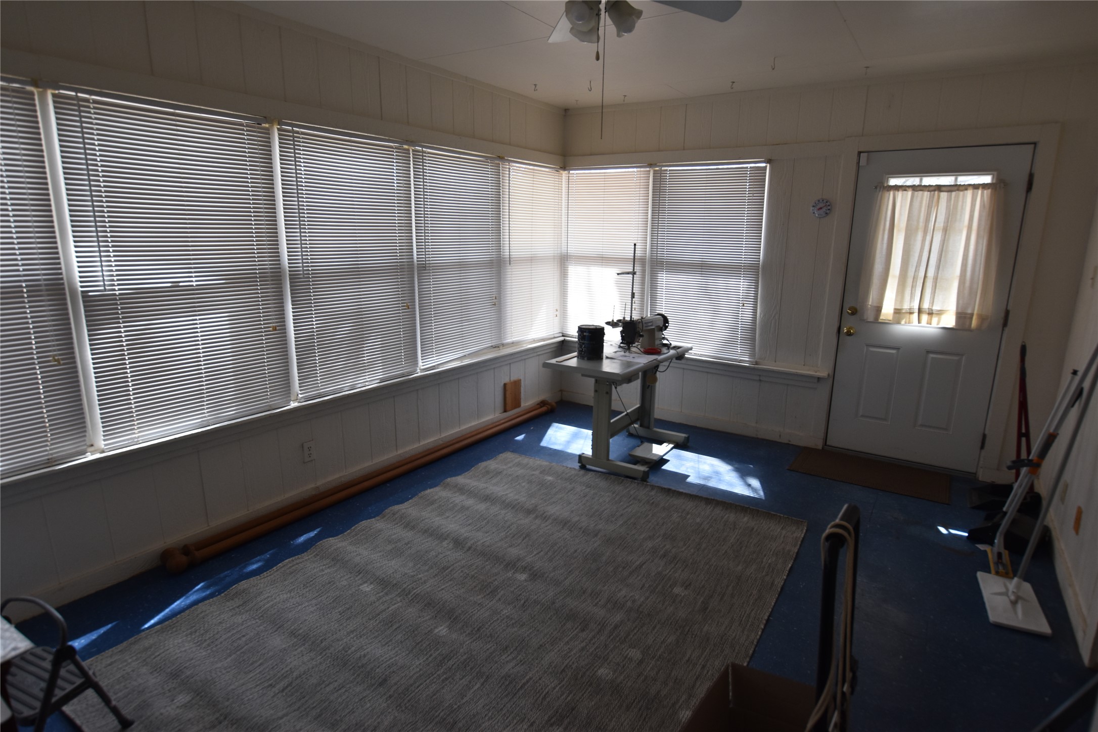 687 Fm 812 Road Red Rock, TX 78662 - Photo 35 of 40 Exercise room with a ceiling fan, plenty of natural light, wood walls, and carpet flooring