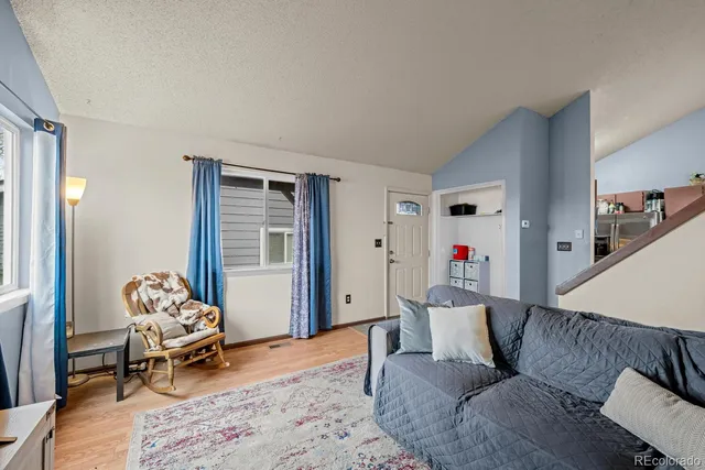a living room with furniture and a wooden floor