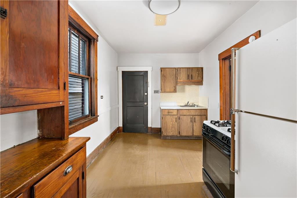 1210 Holmes Street McKees Rocks, PA 15136 - Photo 9 of 44 a kitchen with a refrigerator and a stove top oven