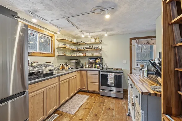 a kitchen with stainless steel appliances granite countertop cabinets and a counter top space