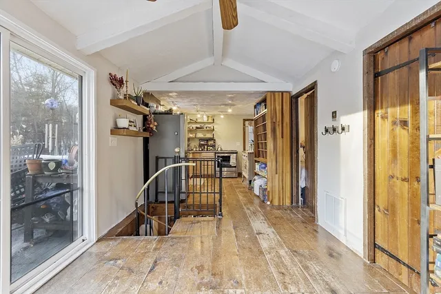a view of a hallway with furniture and a chandelier