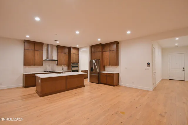 a kitchen that has a sink a microwave oven a stove and white cabinets with wooden floor