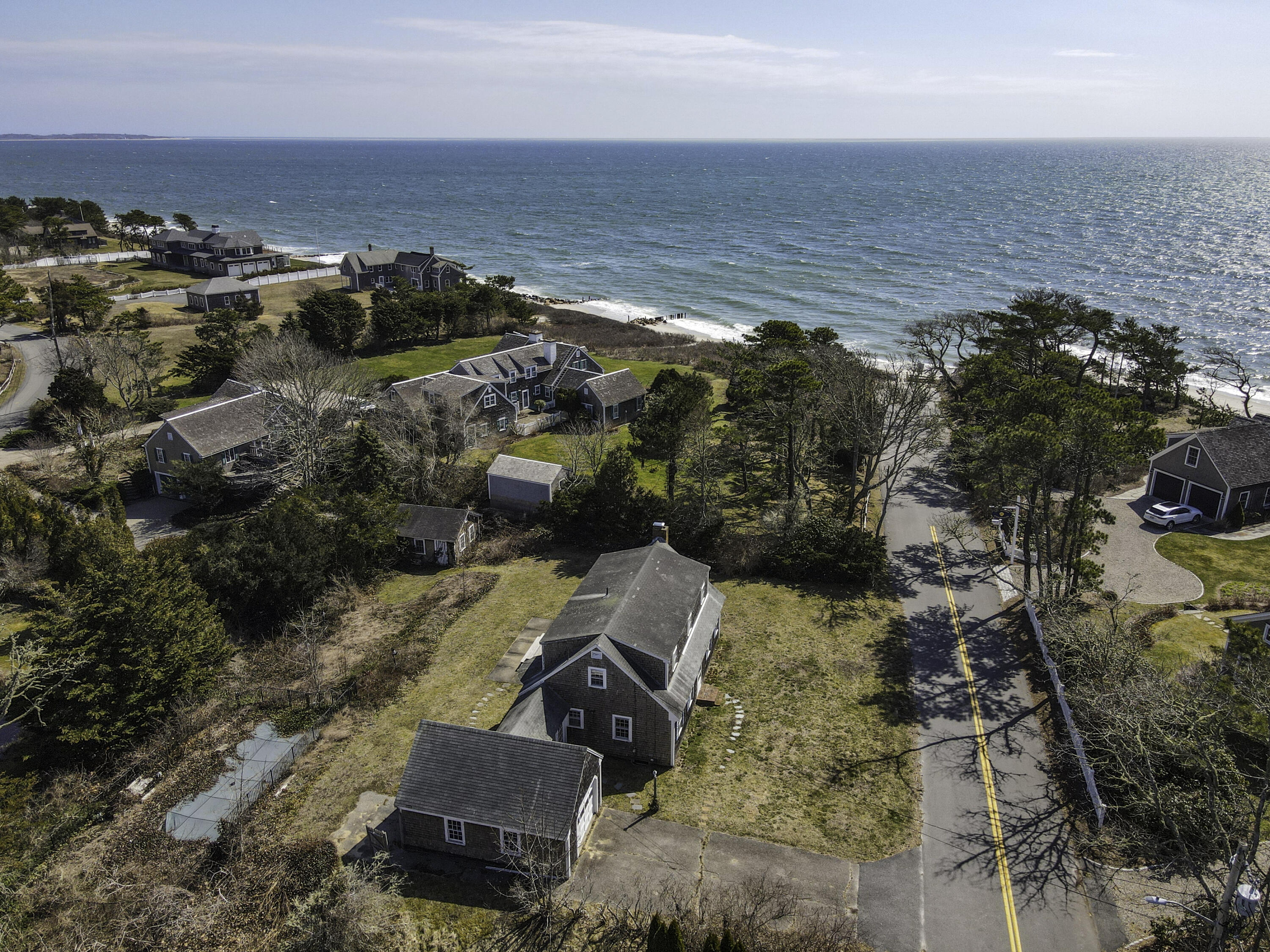 an aerial view of ocean and residential houses with outdoor space