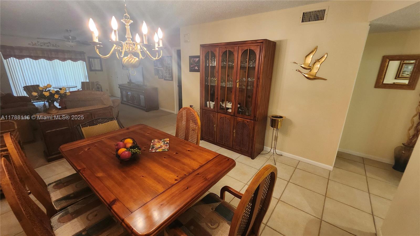 2955 Southwest 22nd Avenue, Unit 1040 Delray Beach, FL 33445 - Photo 16 of 27 a living room with furniture and chandelier