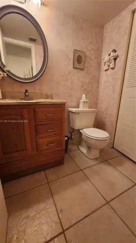 a bathroom with a toilet a sink and mirror