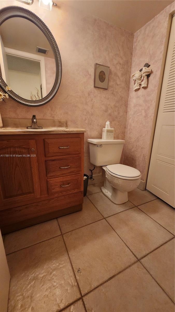2955 Southwest 22nd Avenue, Unit 1040 Delray Beach, FL 33445 - Photo 17 of 27 a bathroom with a toilet a sink and mirror
