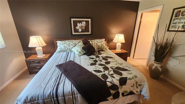 a bed sitting in a bedroom next to a lamp