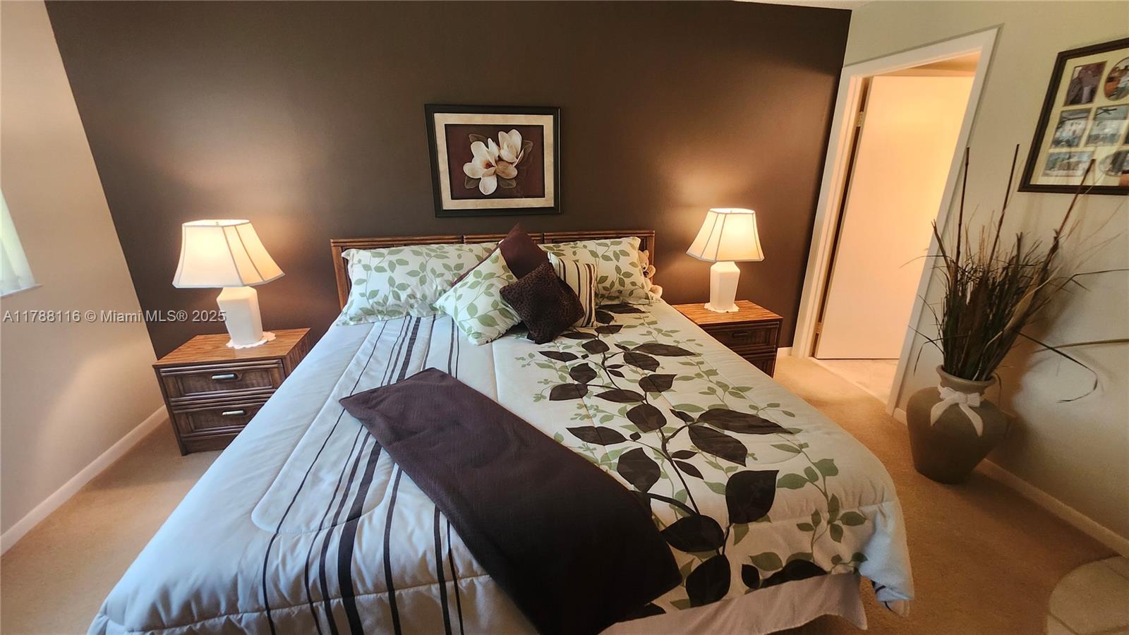 2955 Southwest 22nd Avenue, Unit 1040 Delray Beach, FL 33445 - Photo 3 of 27 a bed sitting in a bedroom next to a lamp