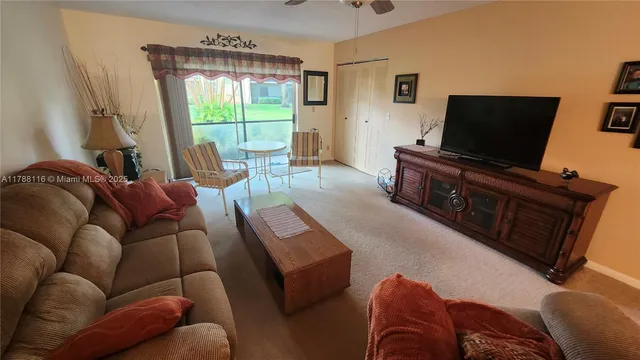 a living room with furniture a flat screen tv and a large window