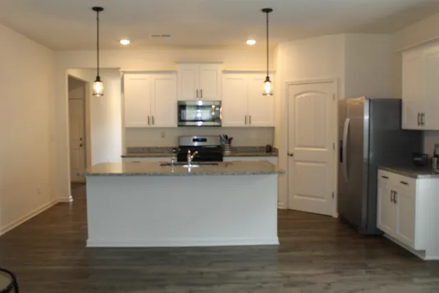 a kitchen with stainless steel appliances a refrigerator sink and stove