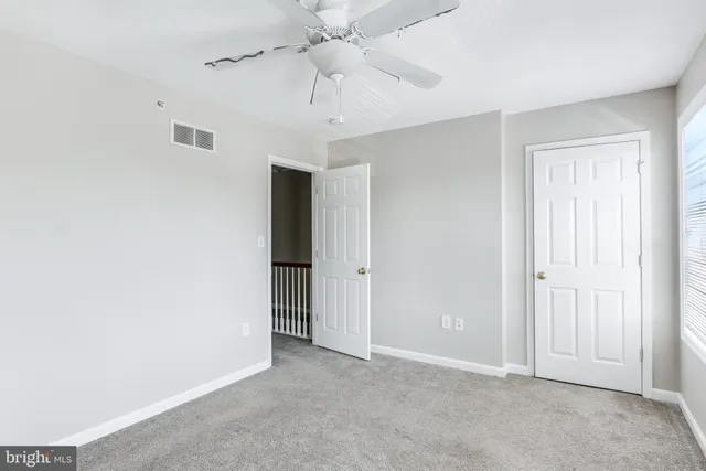 an empty room with a ceiling fan and a window