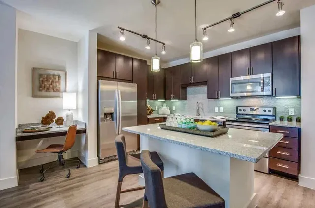 a kitchen with stainless steel appliances granite countertop a sink refrigerator and cabinets