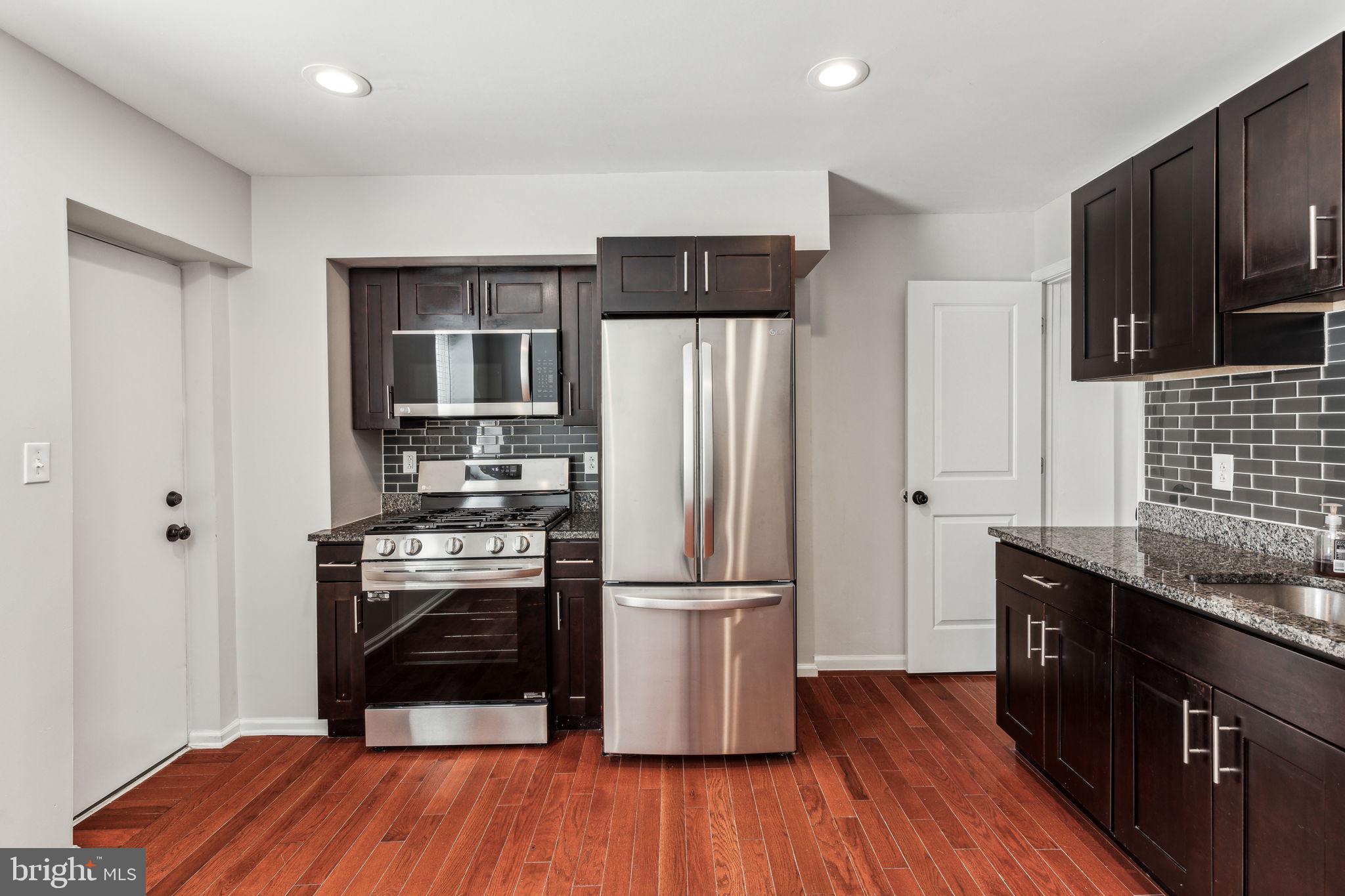 3131 Edgemont Street Philadelphia, PA 19134 - Photo 20 of 39 a kitchen with wooden floors and stainless steel appliances