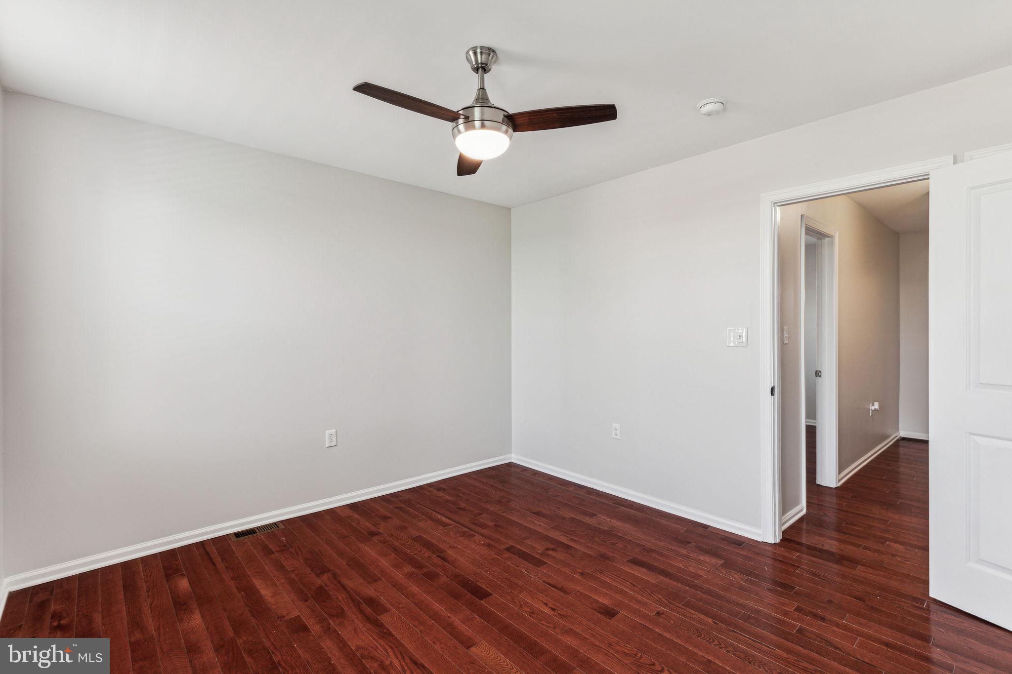 3131 Edgemont Street Philadelphia, PA 19134 - Photo 31 of 39 an empty room with wooden floor and a ceiling fan